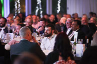 Photography of dinner reception attendee enjoying the presentation